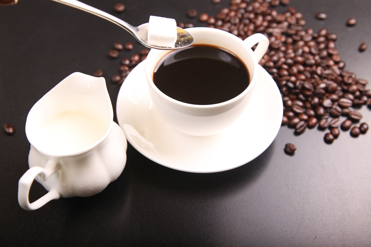 Coffee, sugar cubes, milk and coffee beans